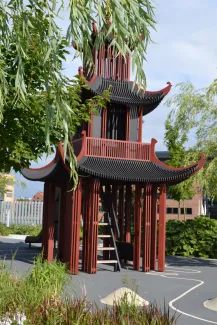 Das asiatisch anmutende Spielhaus mit Rutsche gehört auch zum Kinderbereich. Asiatisch aussehendes Haus im Spielbereich