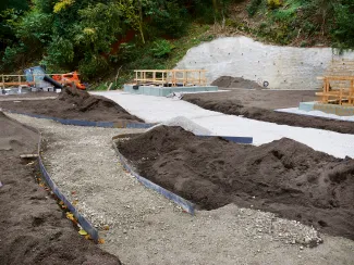 Ob Geh- oder Pflanzbereiche, die durchgängige Dränageebene darunter sichert die Entwässerung auch über die lange Distanz zu den Schmalseiten des Daches. Abgegrenzte Pflanz- und Gehbereiche
