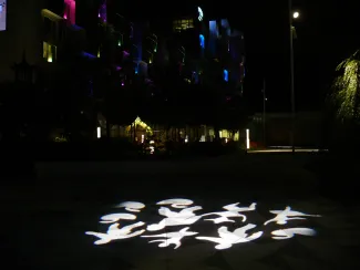 Lichtfiguren tanzen in der Nacht über das Dach, der namensgebende Tivoli-Vergnügungspark lässt grüßen. Lichtfiguren auf den Gehbelägen