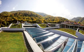 Spielerisches Auf und Ab: die grünen Wellen wechseln sich ab mit einem zickzackförmigen Glasdach. © Danil Kolodin / Tim Flynn architects Geschwungenes Dach mit Begrünung und Glas